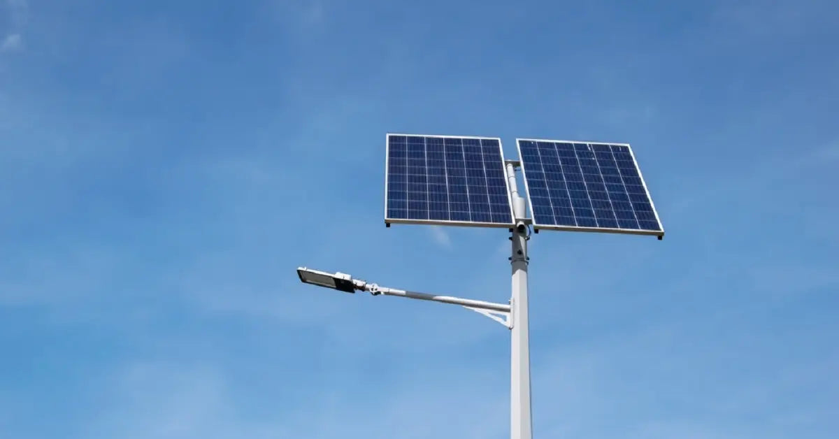 A commercial solar street light with large panels soaking up direct sunlight under a clear blue sky, illustrating the several hours of peak sun needed to achieve a full charge.
