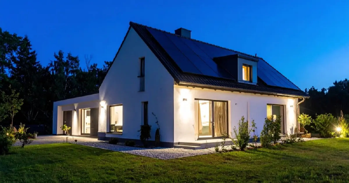 A modern home at dusk with its exterior lit by outdoor solar lights, demonstrating the long-lasting performance of a good solar lighting system.