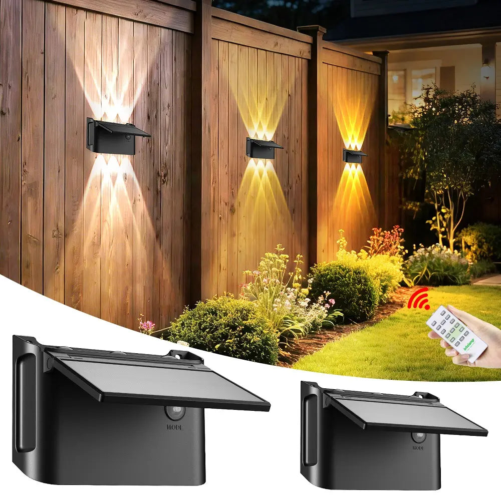 intelamp modern solar up and down wall light with remote control, illuminating a wooden garden fence.
