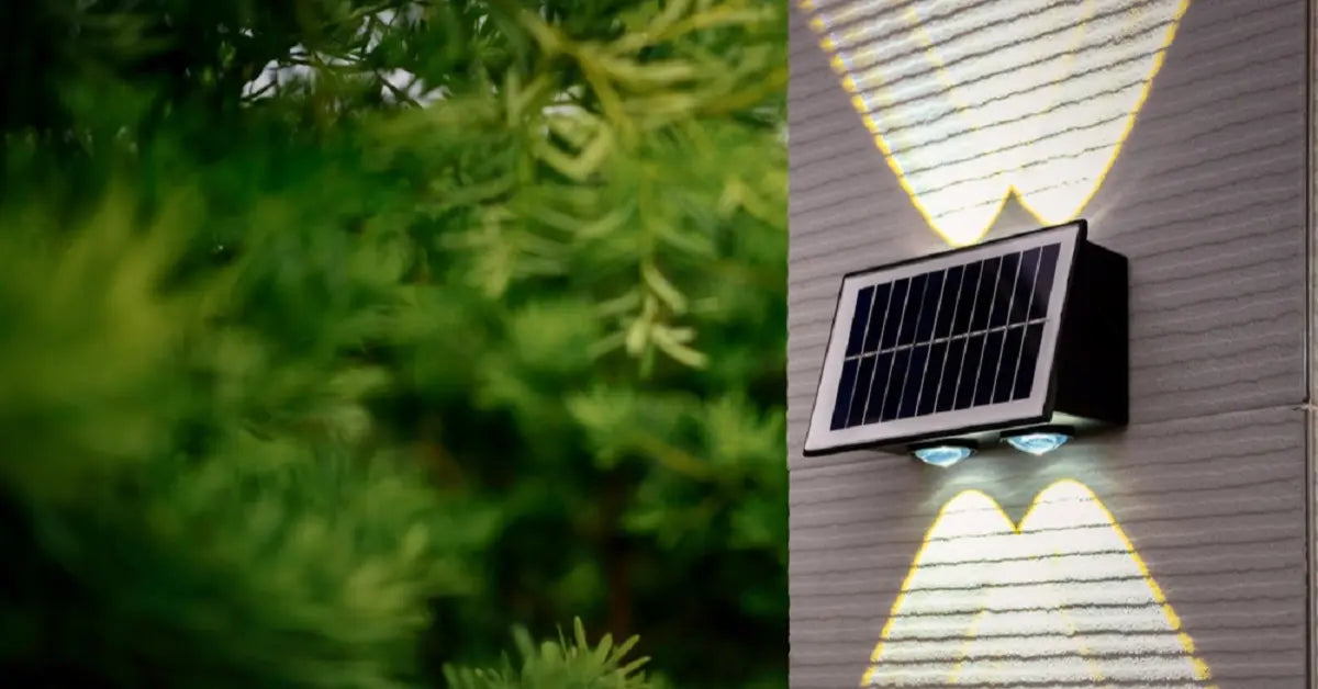 Decorative solar-powered wall light emitting heart-shaped light patterns on a textured wall, next to green foliage