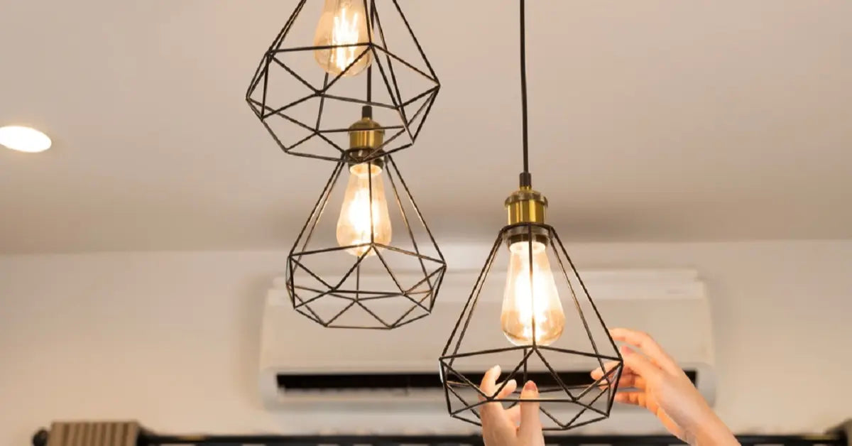 Hands adjusting electric LED light with diamond cage design, highlighting indoor electric lighting fixture design and installation