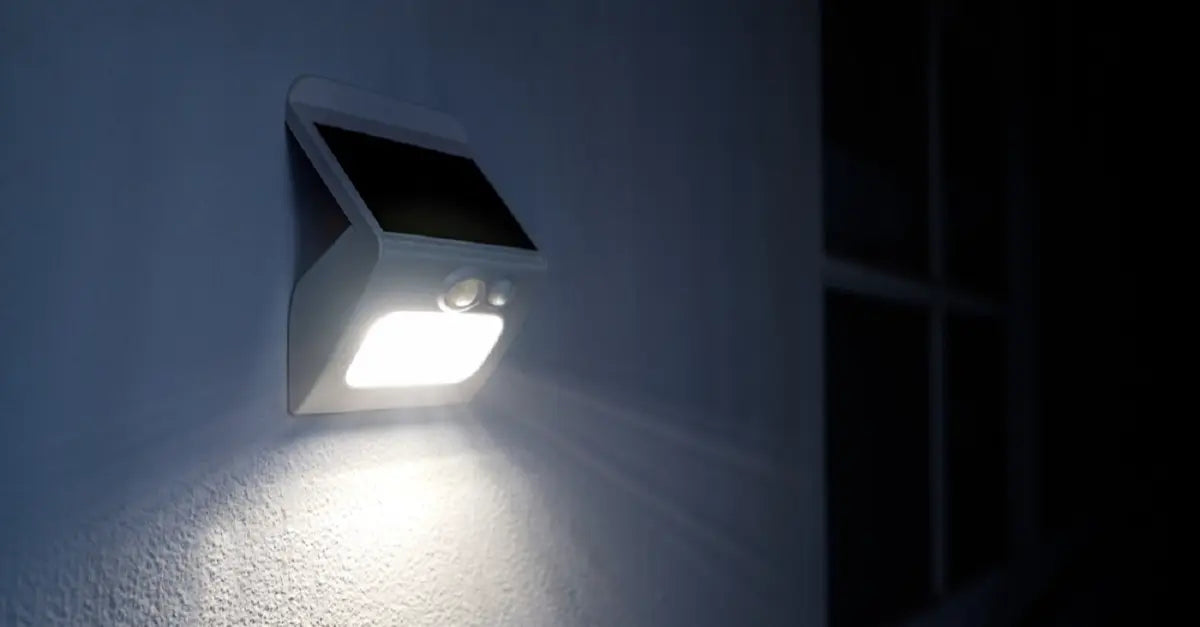 Outdoor solar motion sensor wall light brightly illuminating a house wall at night, showcasing the performance of solar-powered LED lights