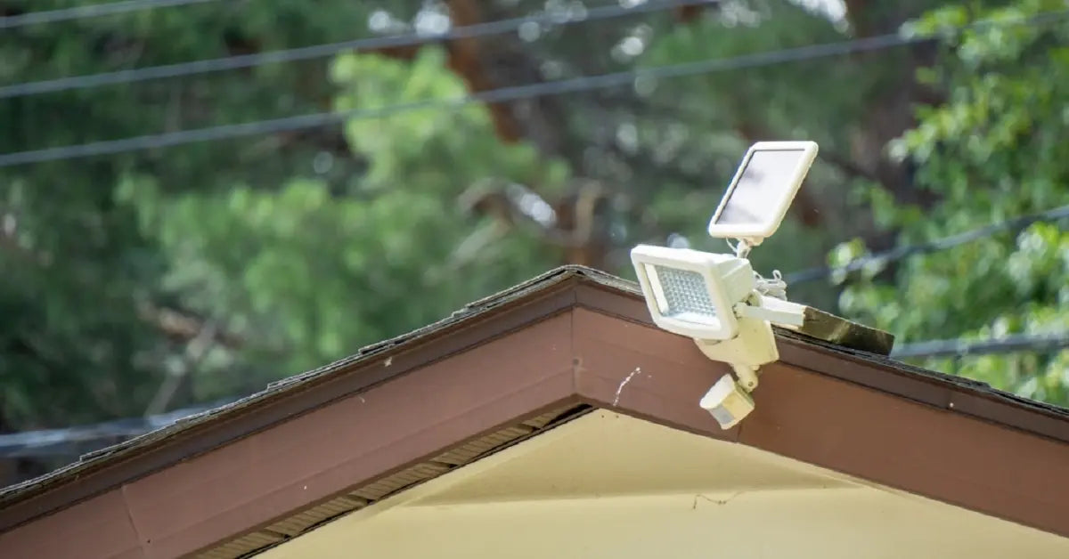 A solar security light on a roof with its adjustable panel positioned for direct sunlight, which is crucial for reducing how long solar lights take to charge.