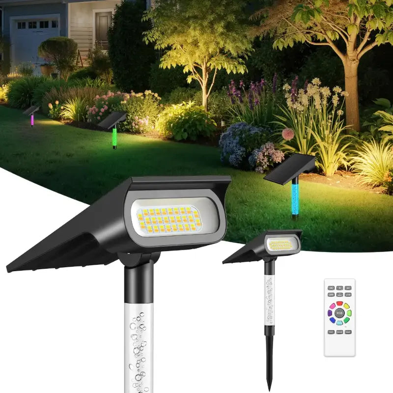 Color changing solar spot lights illuminating a garden pathway and trees at night
