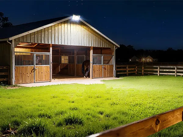 Outdoor solar flood light night illumination application for horse barn stable farm pasture building